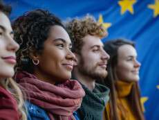 four-young-adults-diverse-smiling-stand-confidently-against-backdrop-european-flag-symb